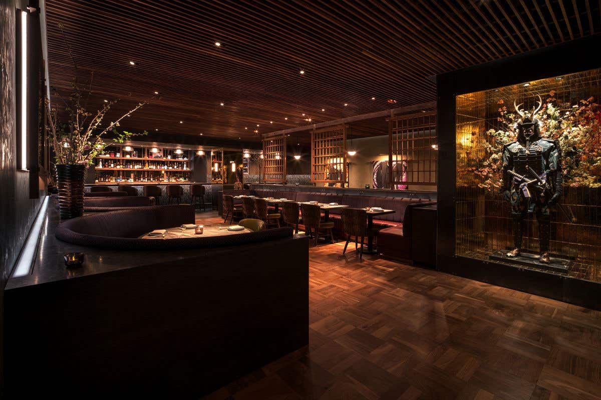 Warm, elegant dining room featuring booth seating and a samurai figure.