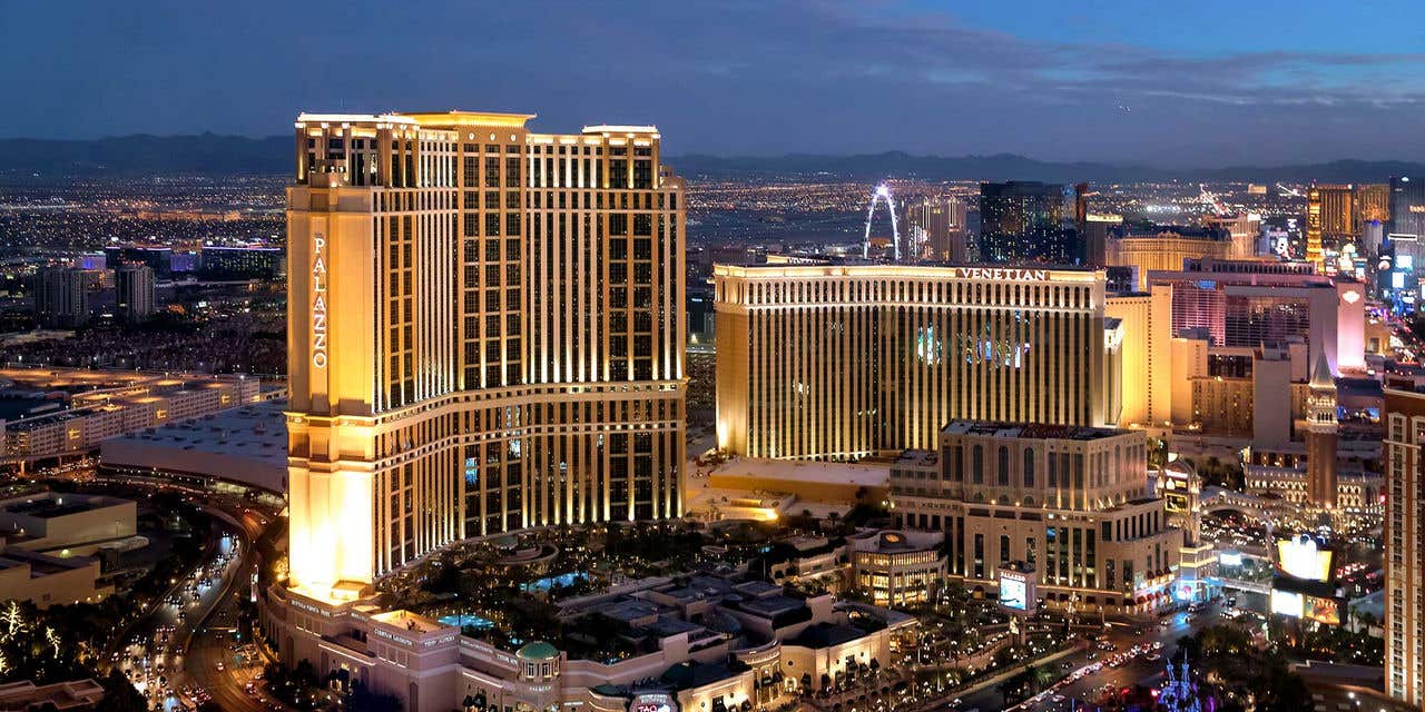 Exterior aerial shot of The Venetian Resort. The Palazzo tower rises on the left, The Venetian North Tower rises on the right.