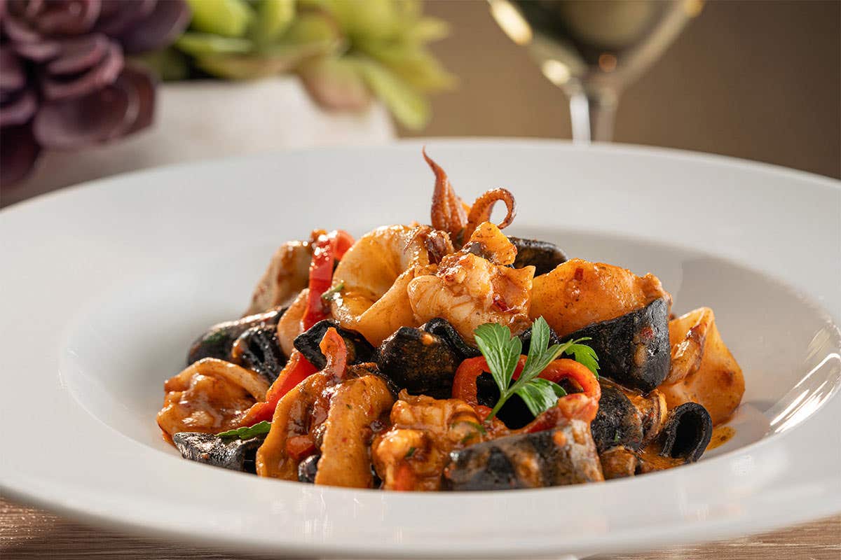 Calamarata pasta with a red sauce and pieces if calamari 